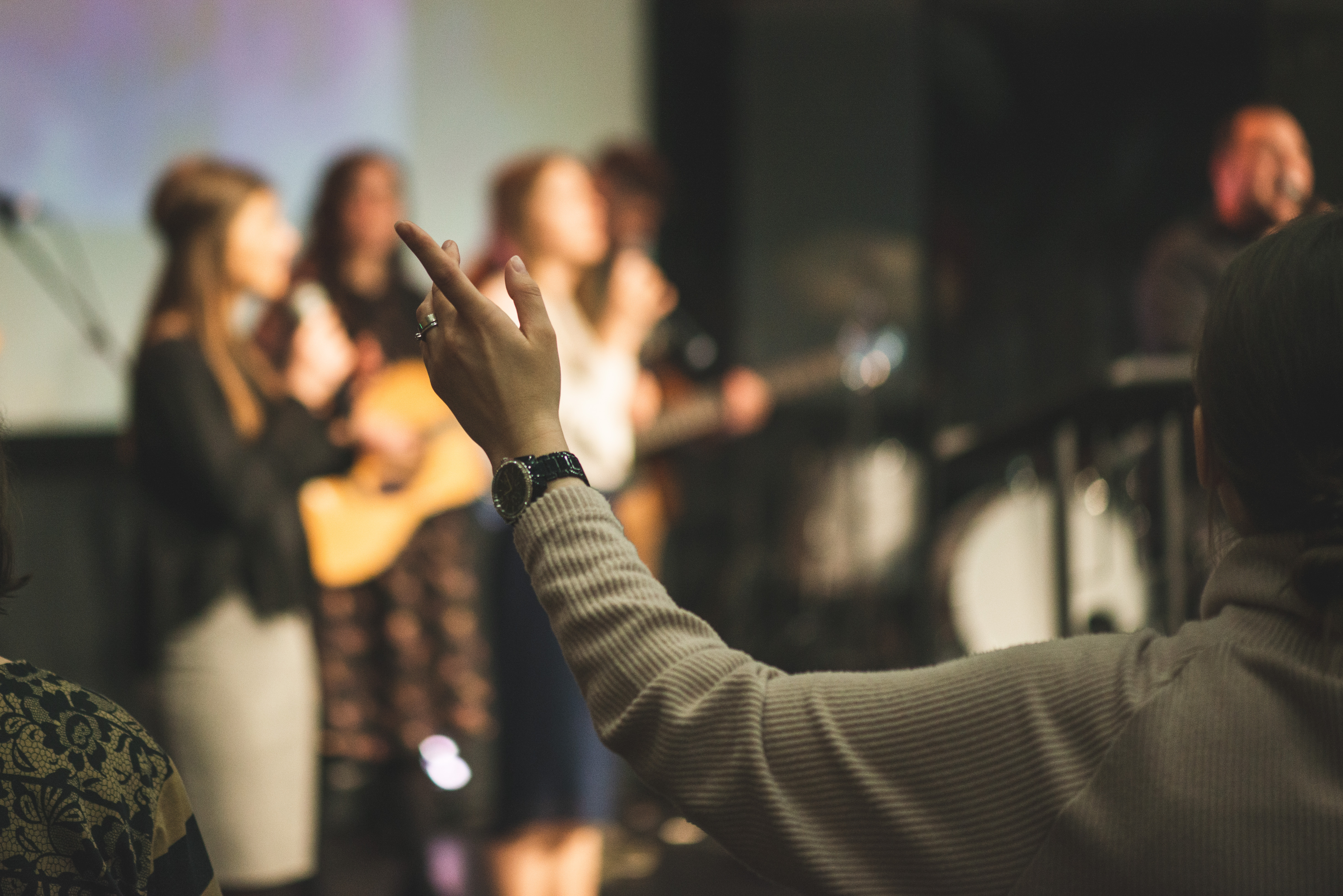Hands in the air of a woman who praise God at church service