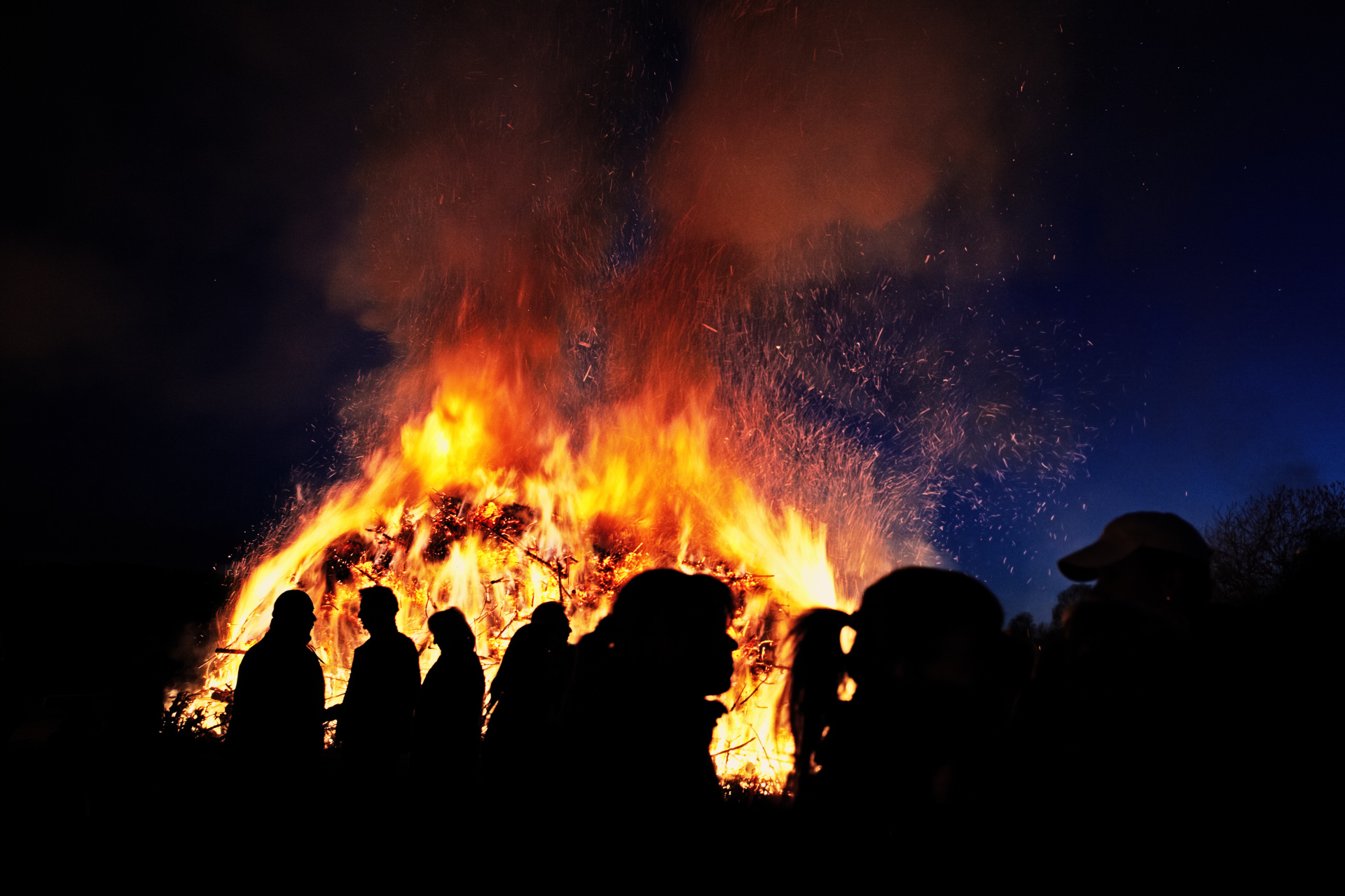 People standing in front of a traditional Easter fire in Germany People standing in front of a traditional Easter fire in Germany