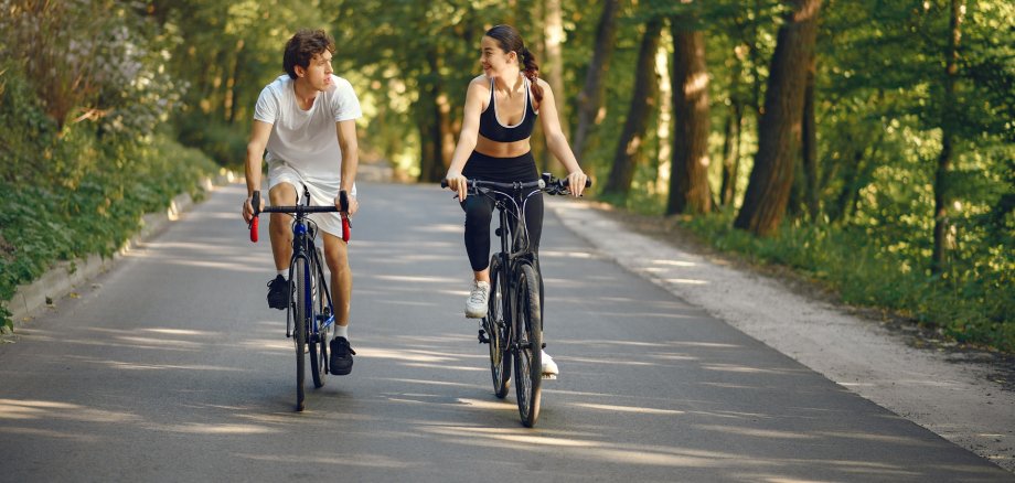 Sports couple riding bikes in summer forest Sports couple riding bikes in summer forest