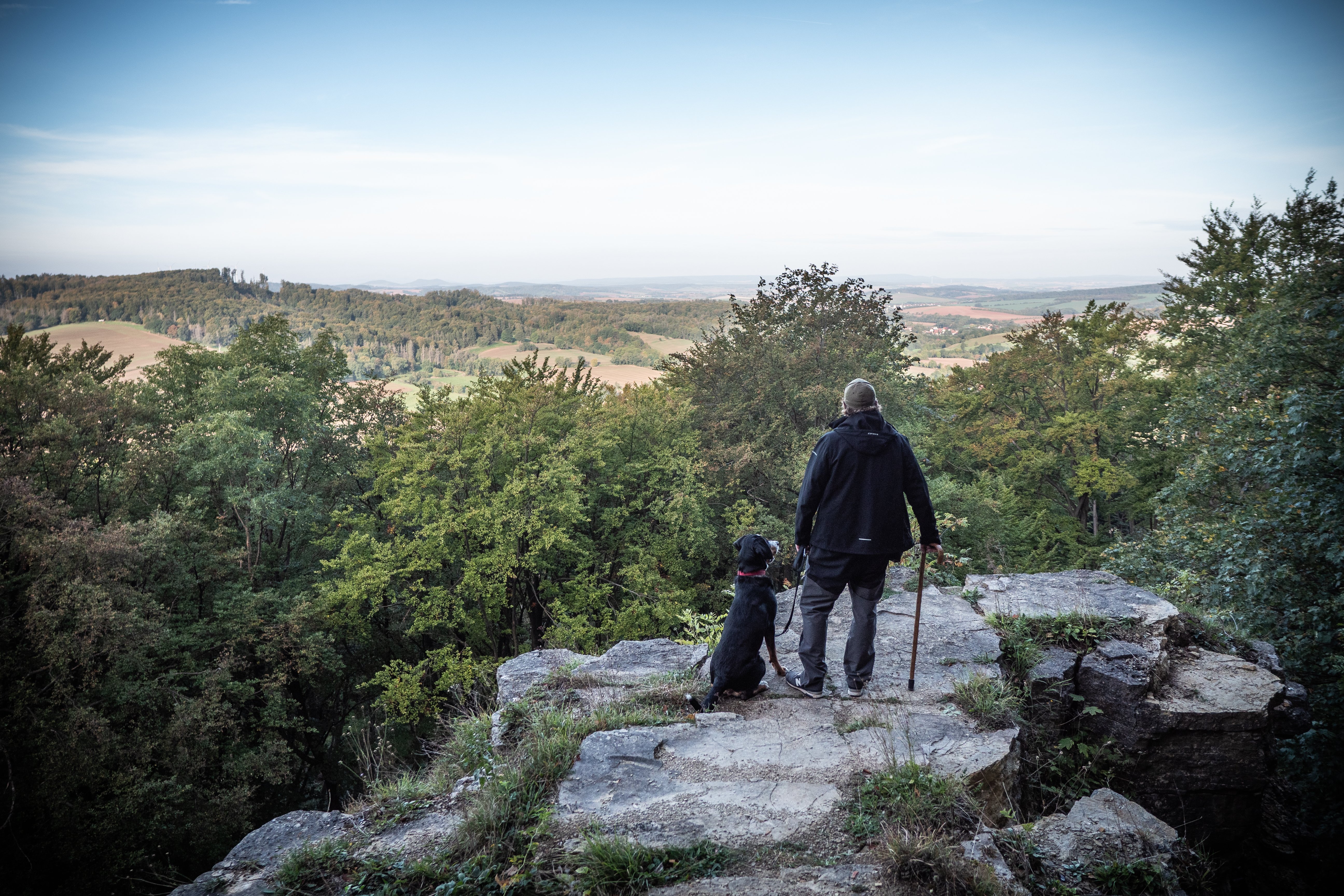 Wanderer mit Hund am Kanstein im Ohmgebirge.
